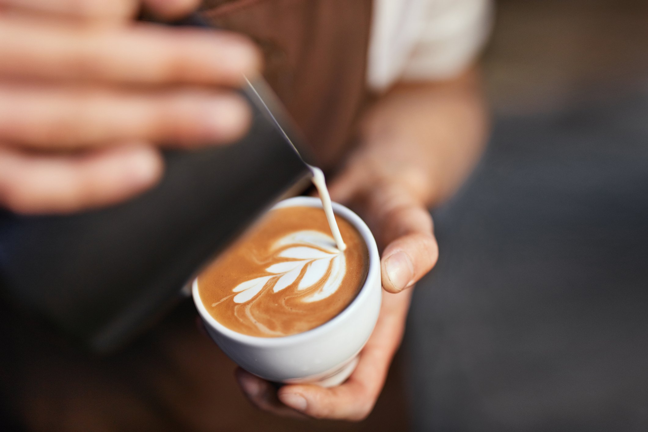 Coffee Art In Cup. Closeup Of Barista Hands Making Latte Art Picture With Milk On Coffee