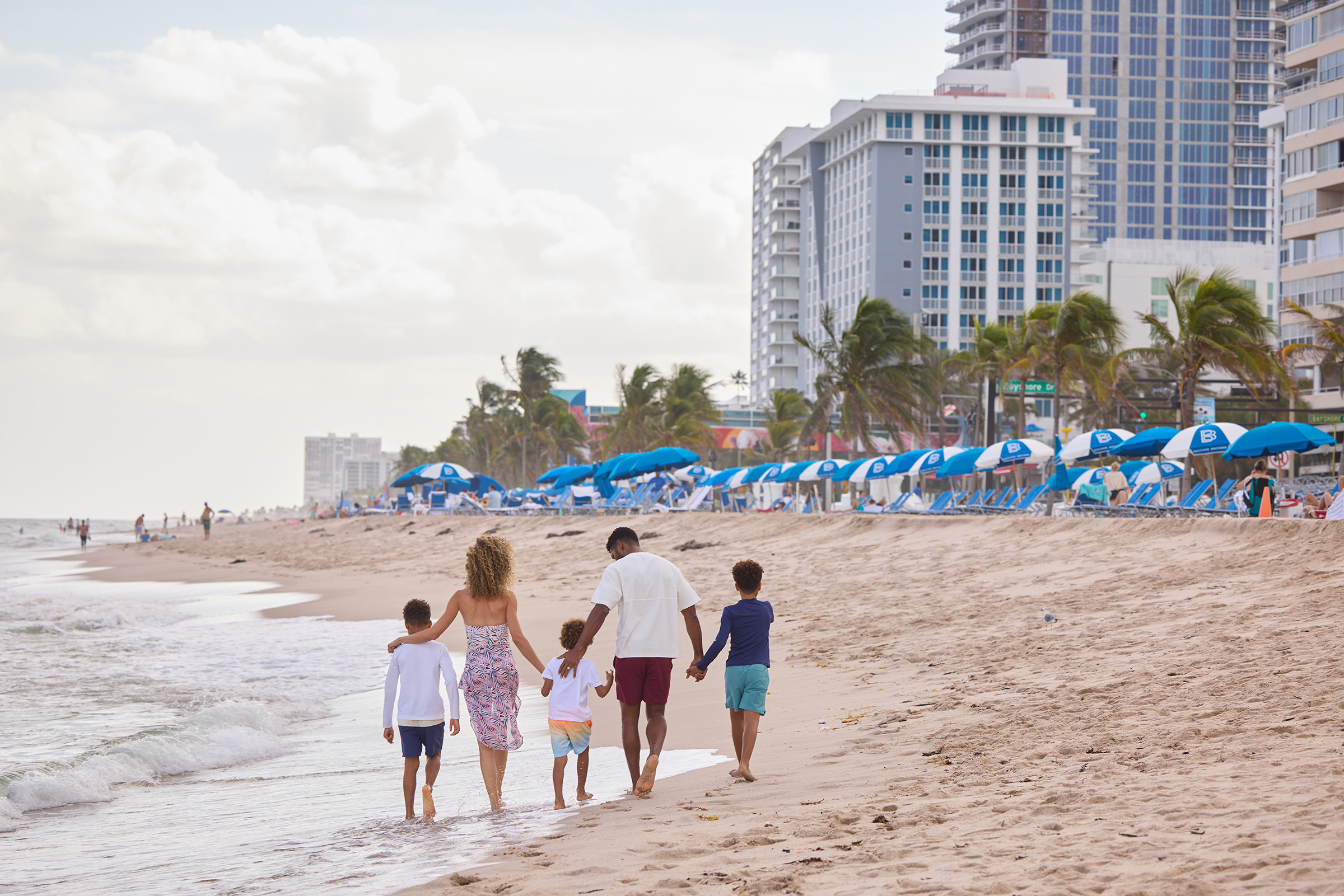 A family walking arm in arm along the beach