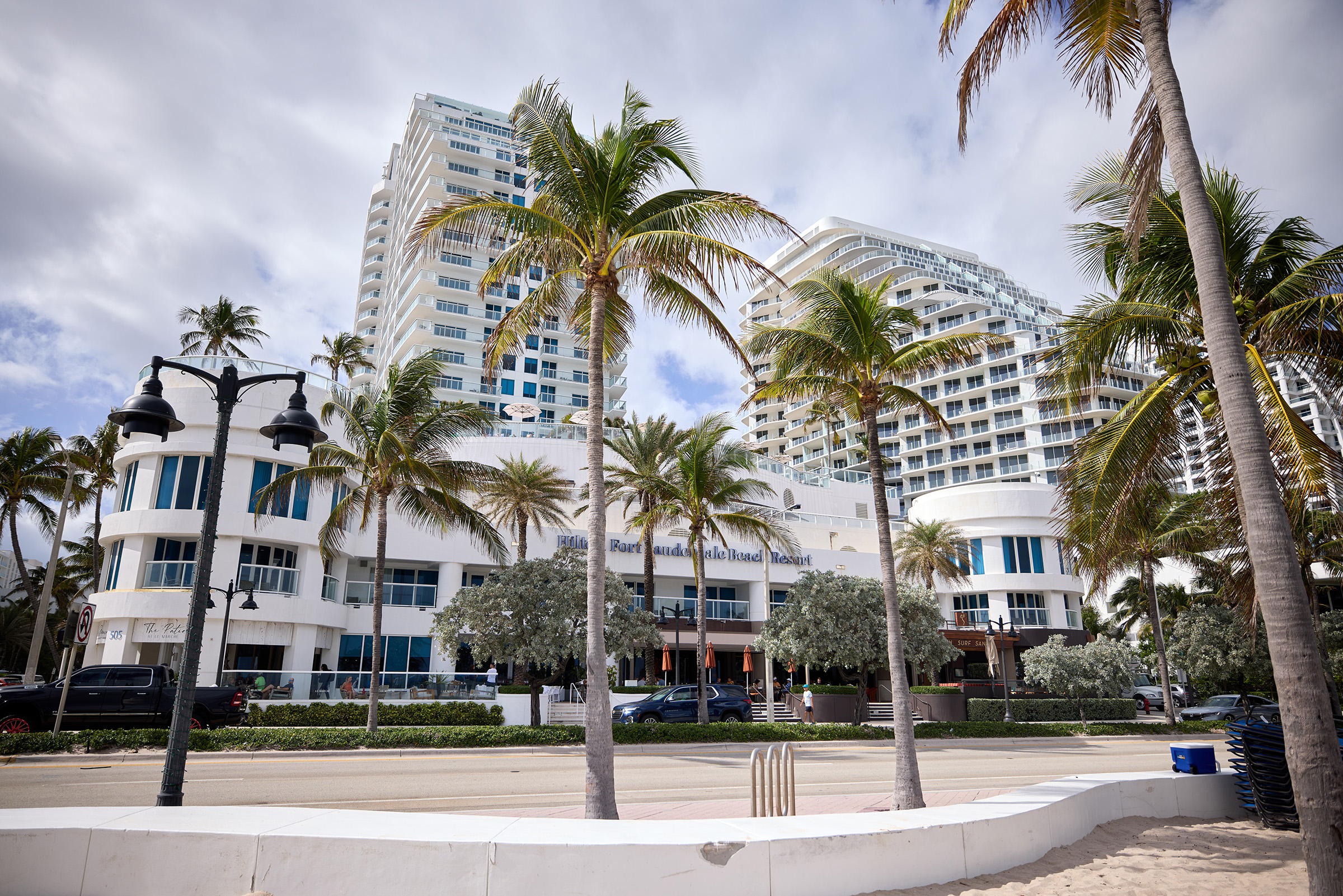 An exterior view of the ground level of the resort, surrounded by pal trees