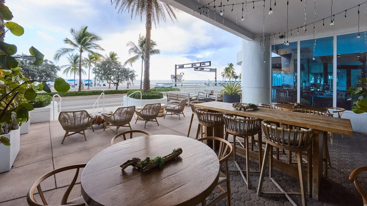 Wood tables and seating at Le Marche facing the Fort Lauderdale beach.