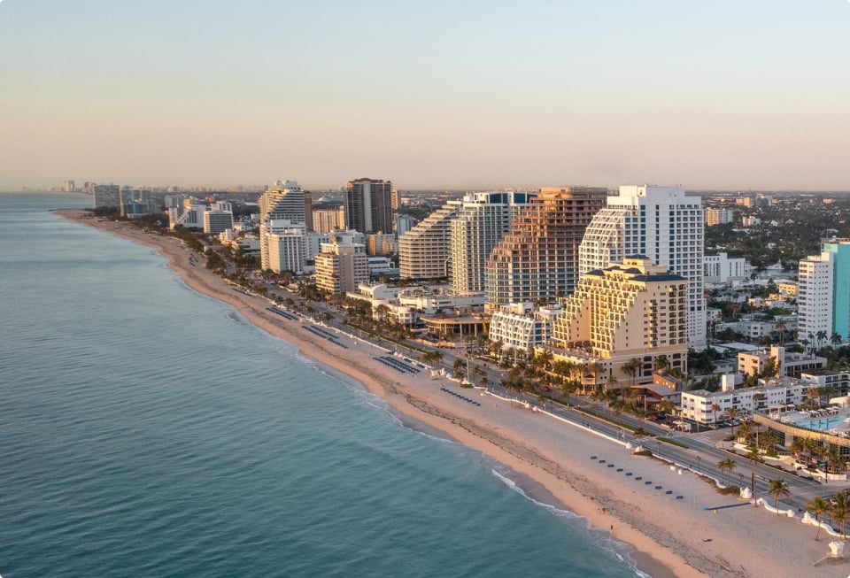 an aerial view of the fort Lauderdale beach with hotels and resorts lining the beachfront at sunset