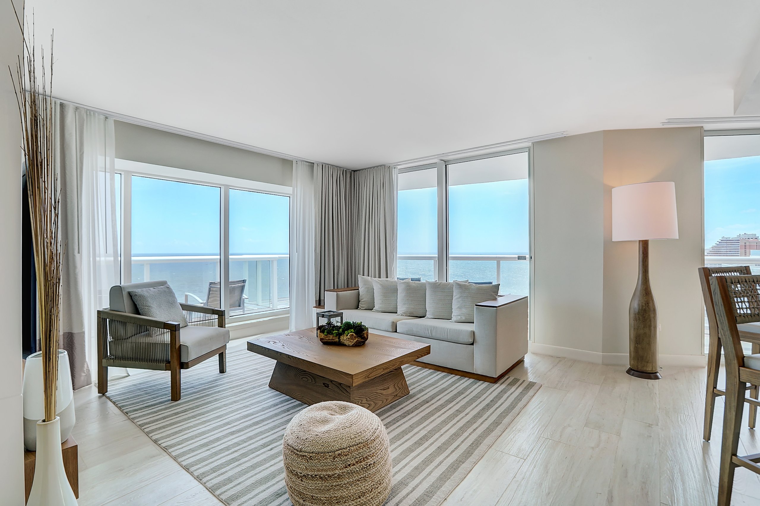 Comfortable couch and arm chair in a large living room with balcony of ocean view