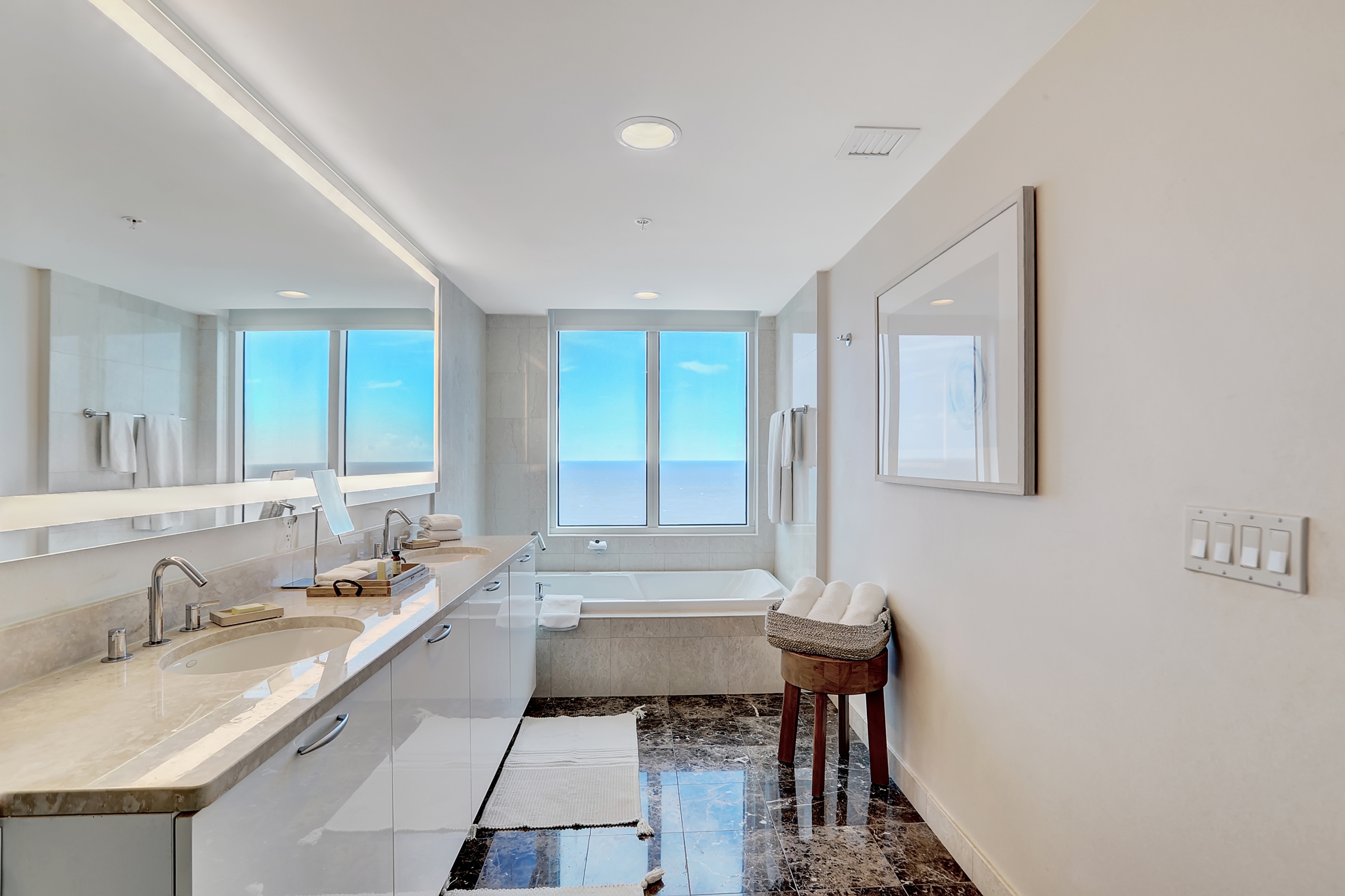White bathtub with large window of ocean view in modern bathroom