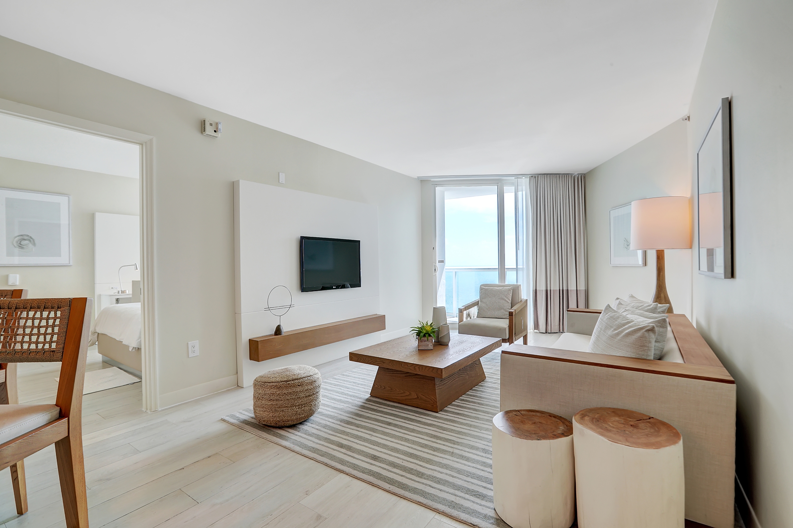 A large living space for white wooden couch, tex table, and comfortable arm chair