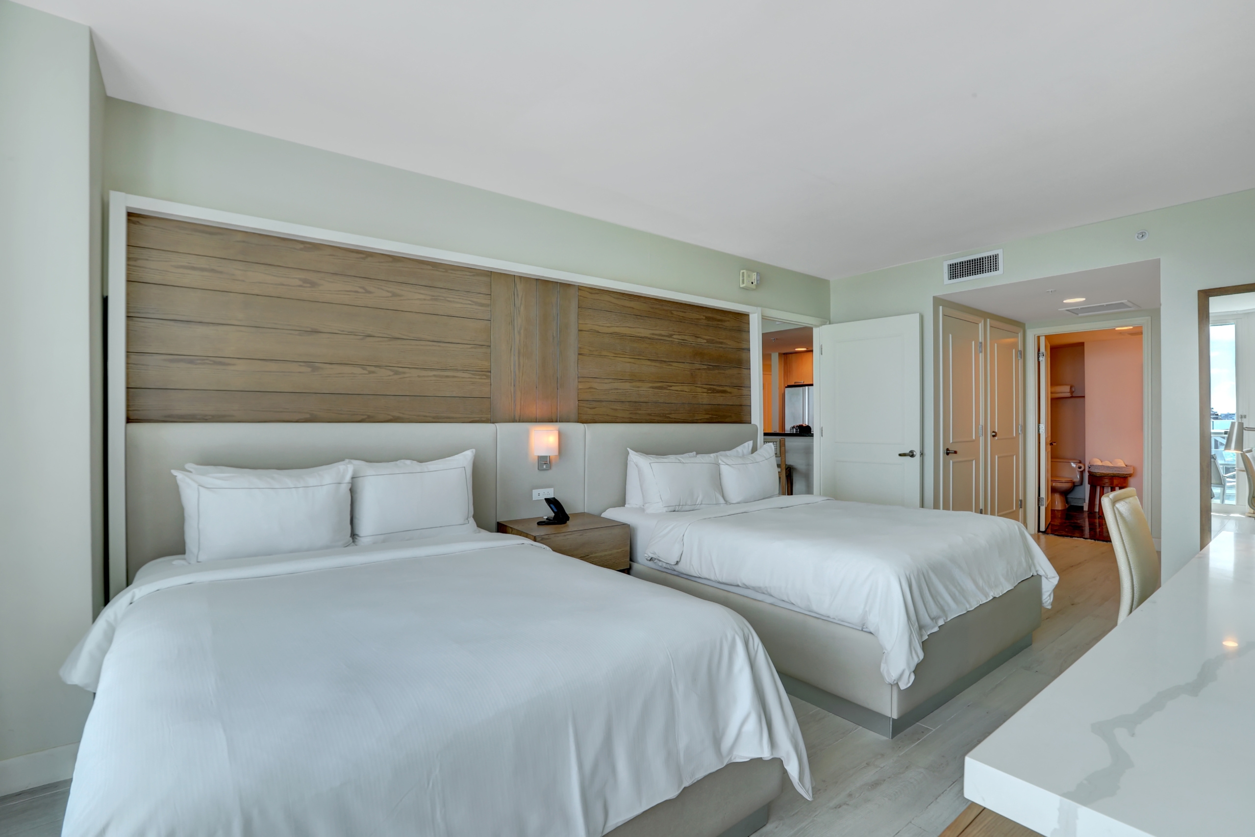 Two queen beds with white sheets in modern bedroom