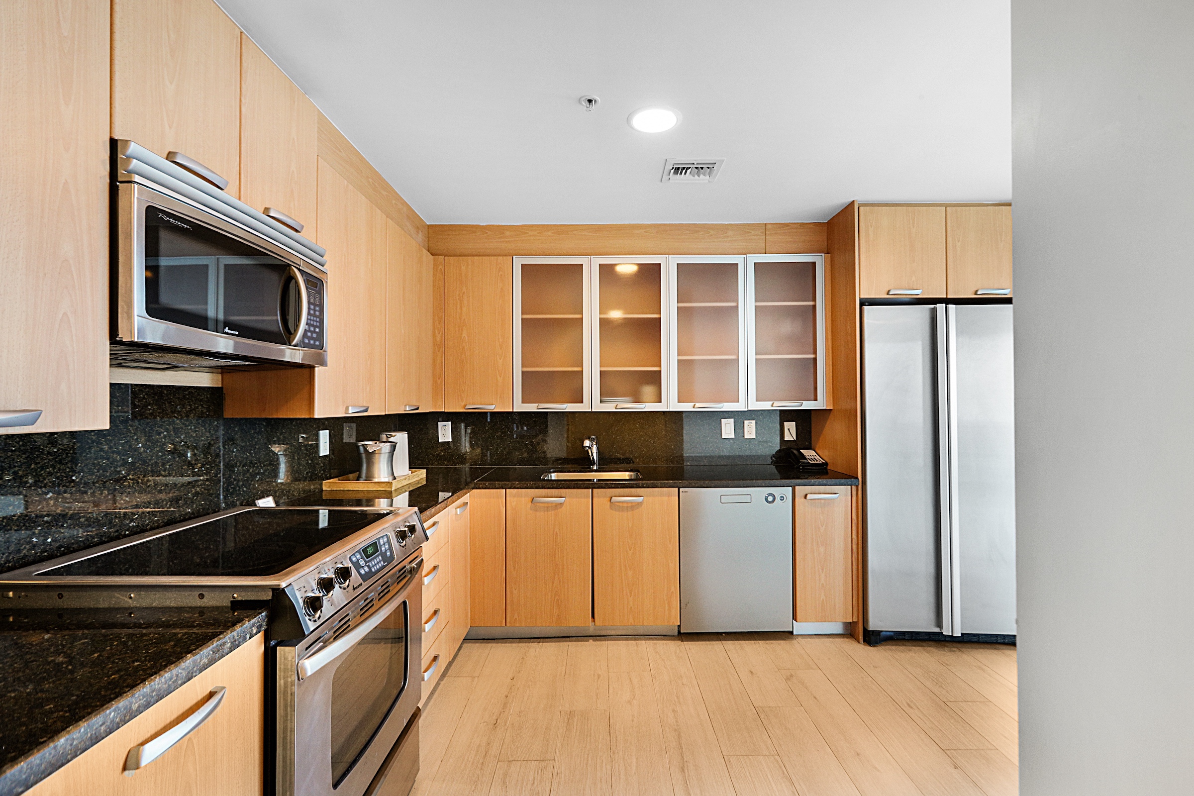 A kitchen with a full sized fridge, dishwasher and range oven