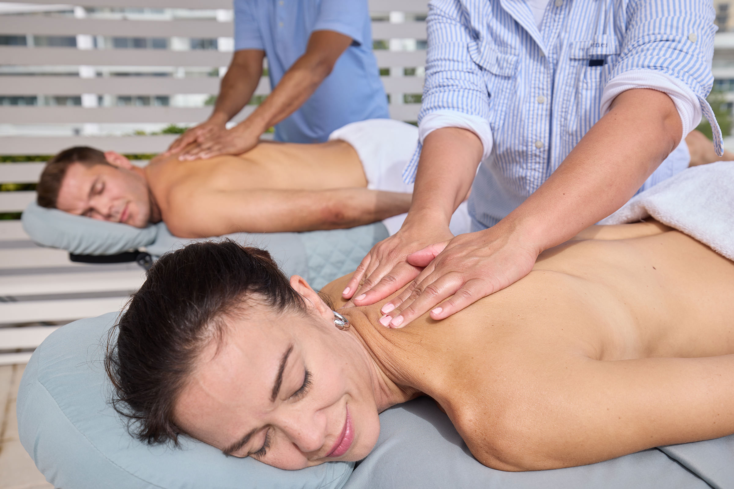 A couple receiving soothing massages in a tranquil spa environment, surrounded by calming decor