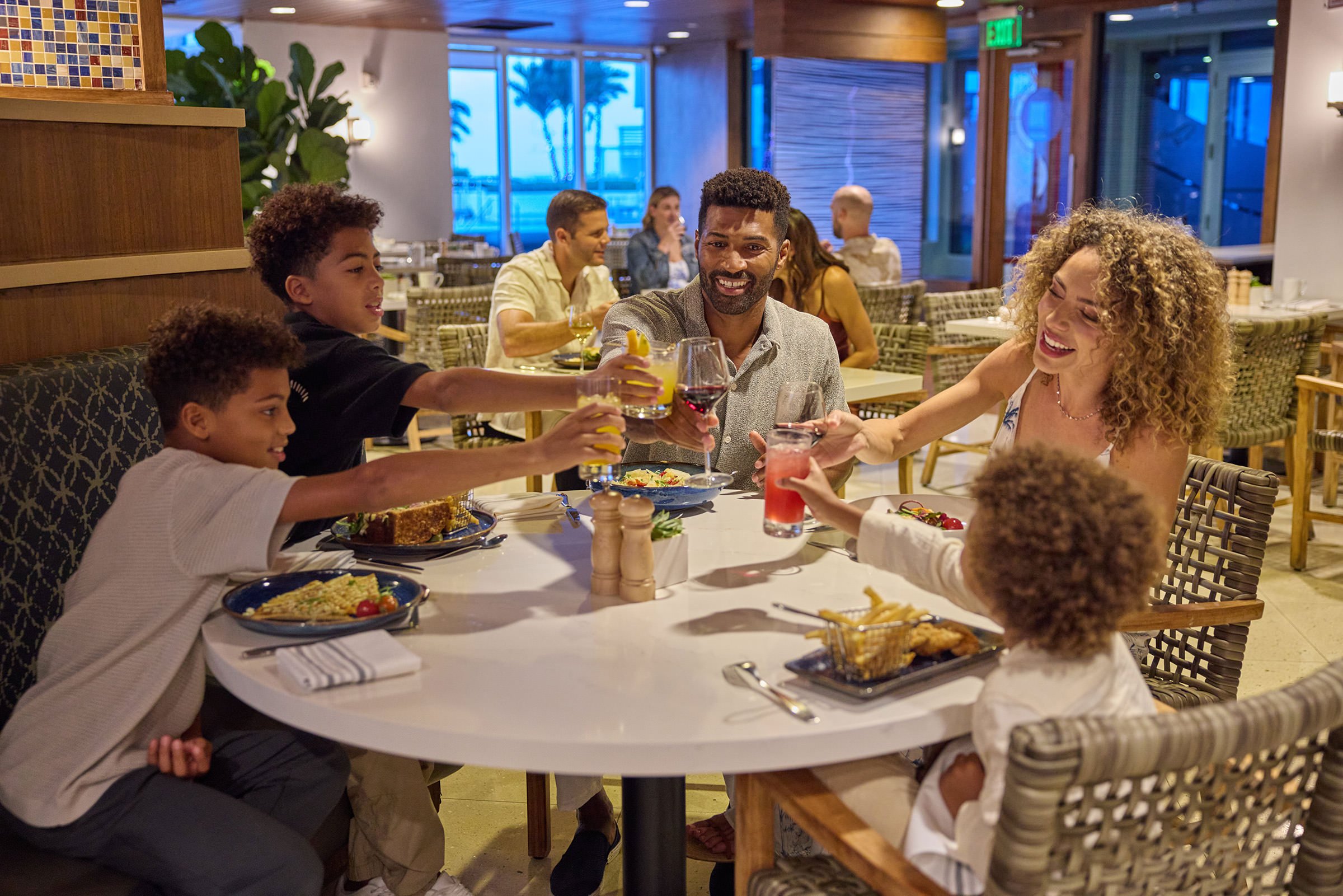 Family dining and cheering their drinks at Ilios restaurant