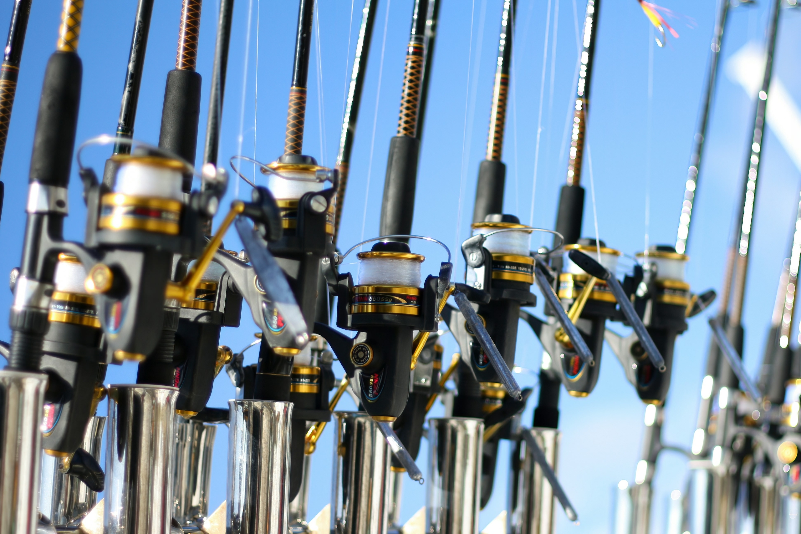 a row of black and gold fishing rods