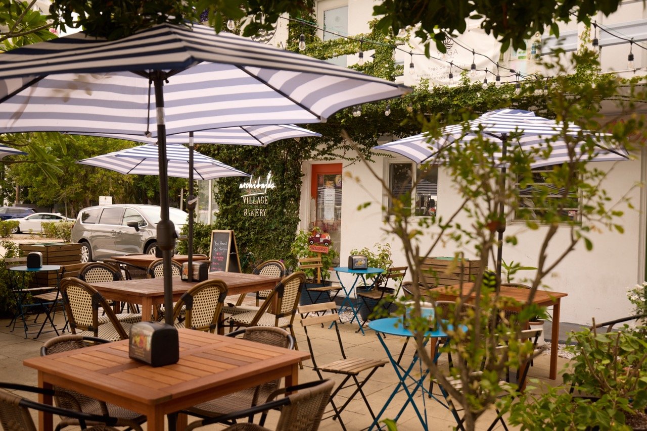 the patio at la march with stripped table umbrellas over wood tables and chairs