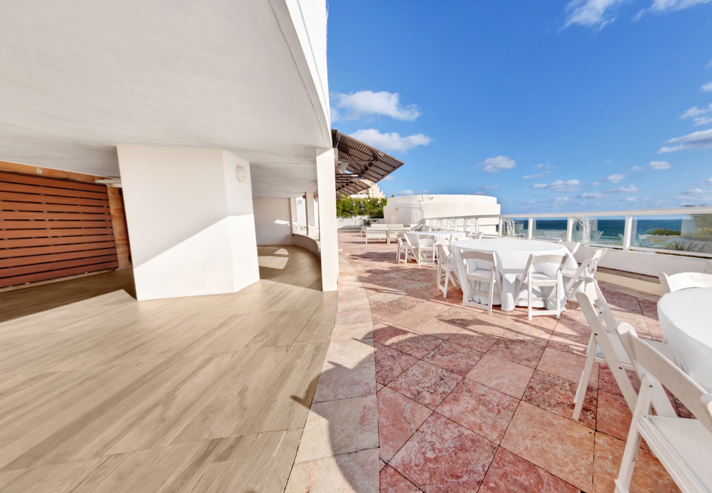 A terrace under an awning next to a beach side balcony patio