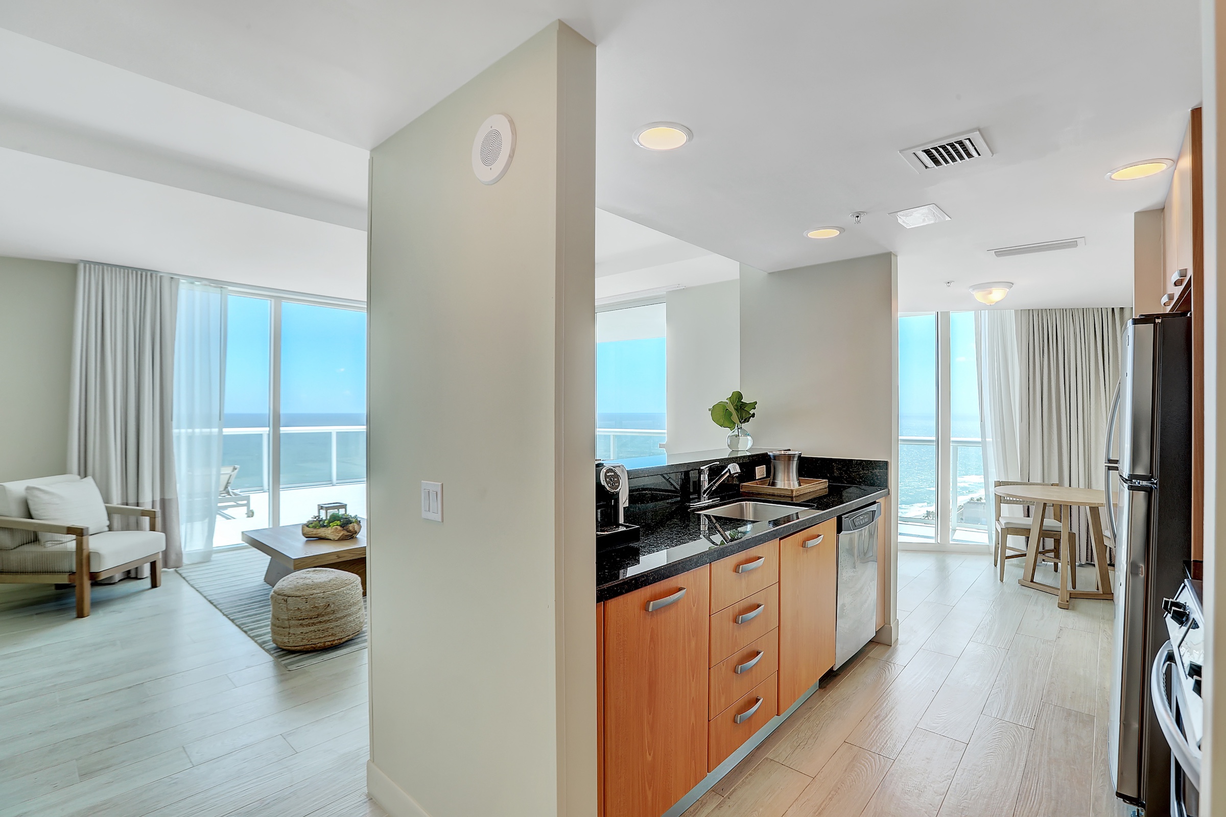A galley kitchen with half-walls separating it from an oceanfront living room