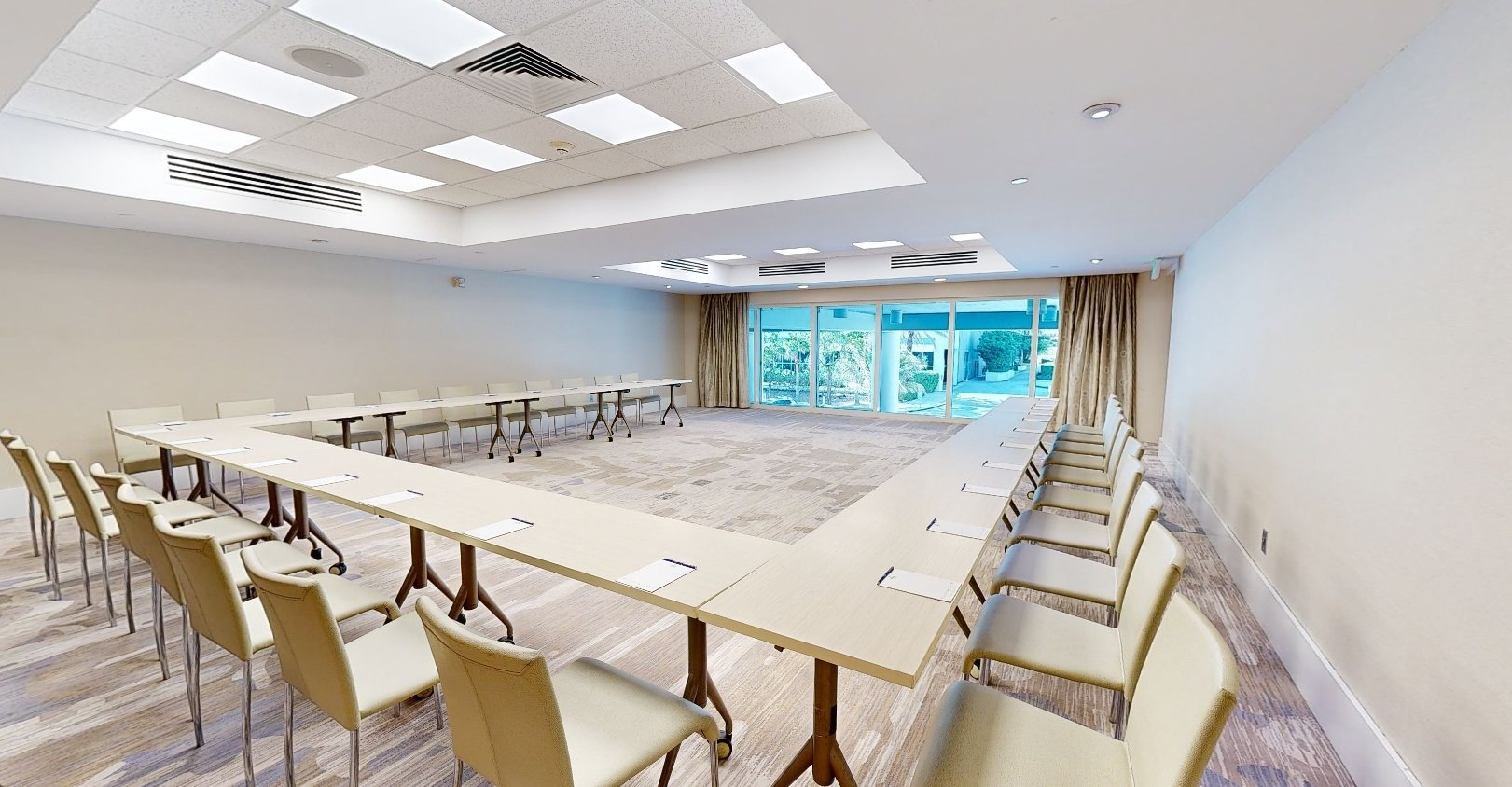 Beach House Fort Lauderdale Aurinko meeting room, featuring a hollow square meeting table and chairs and a bay window looking out on a terrace