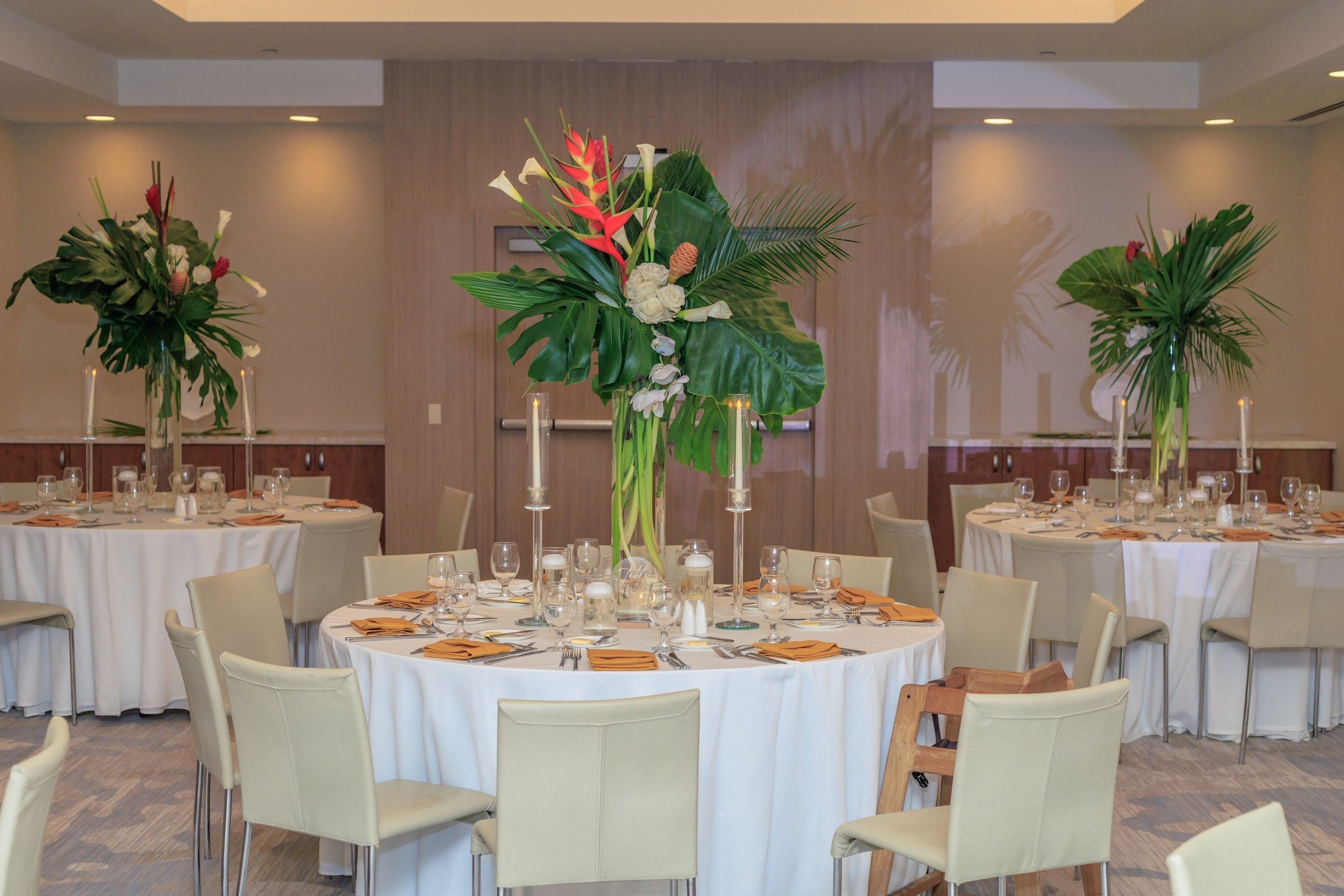 The Jua room at Beach House Fort Lauderdale, decorated for a weddign with white linen-topped tables decorated with large floral centerpieces