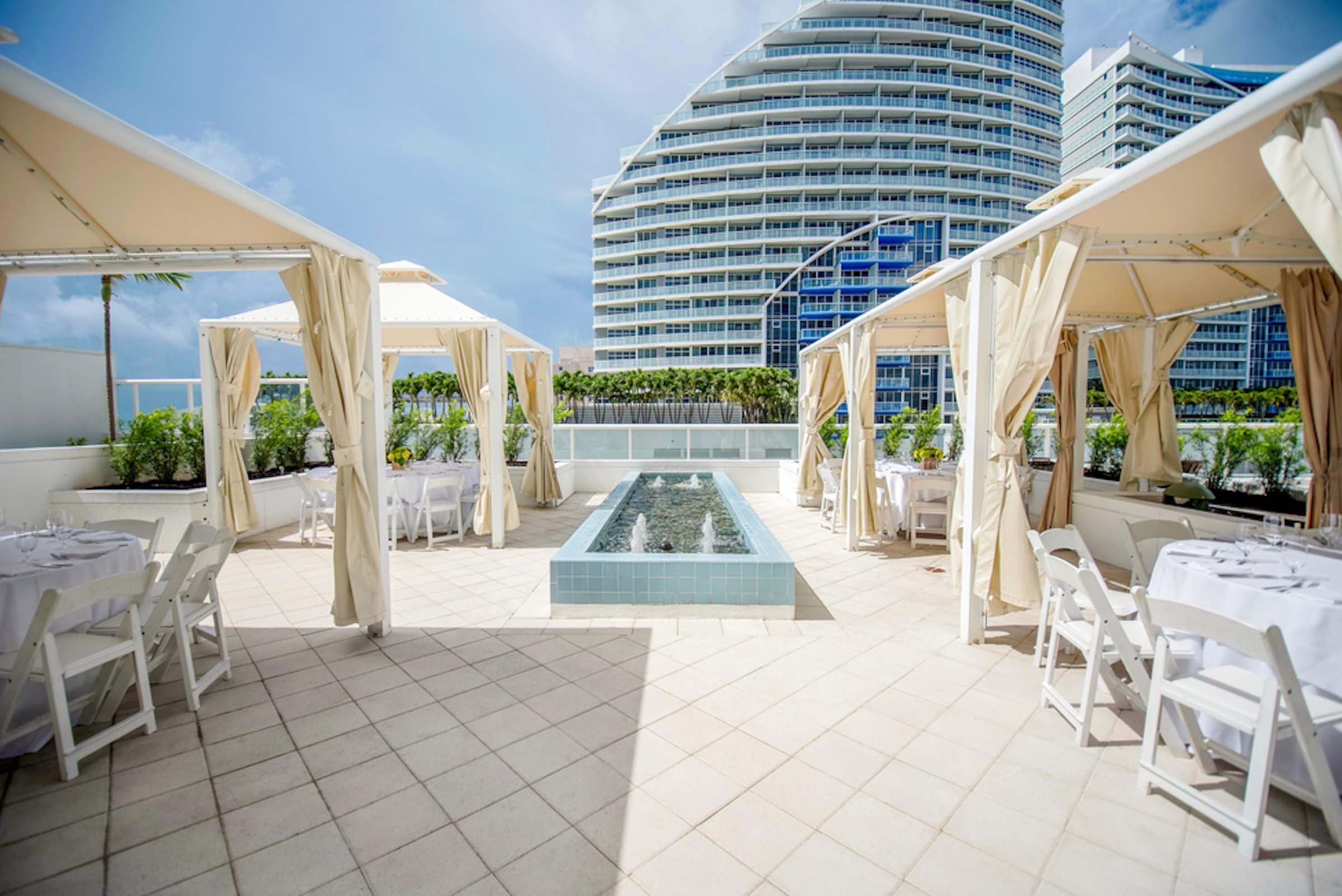 A terrace with a row of pool cabanas on either side