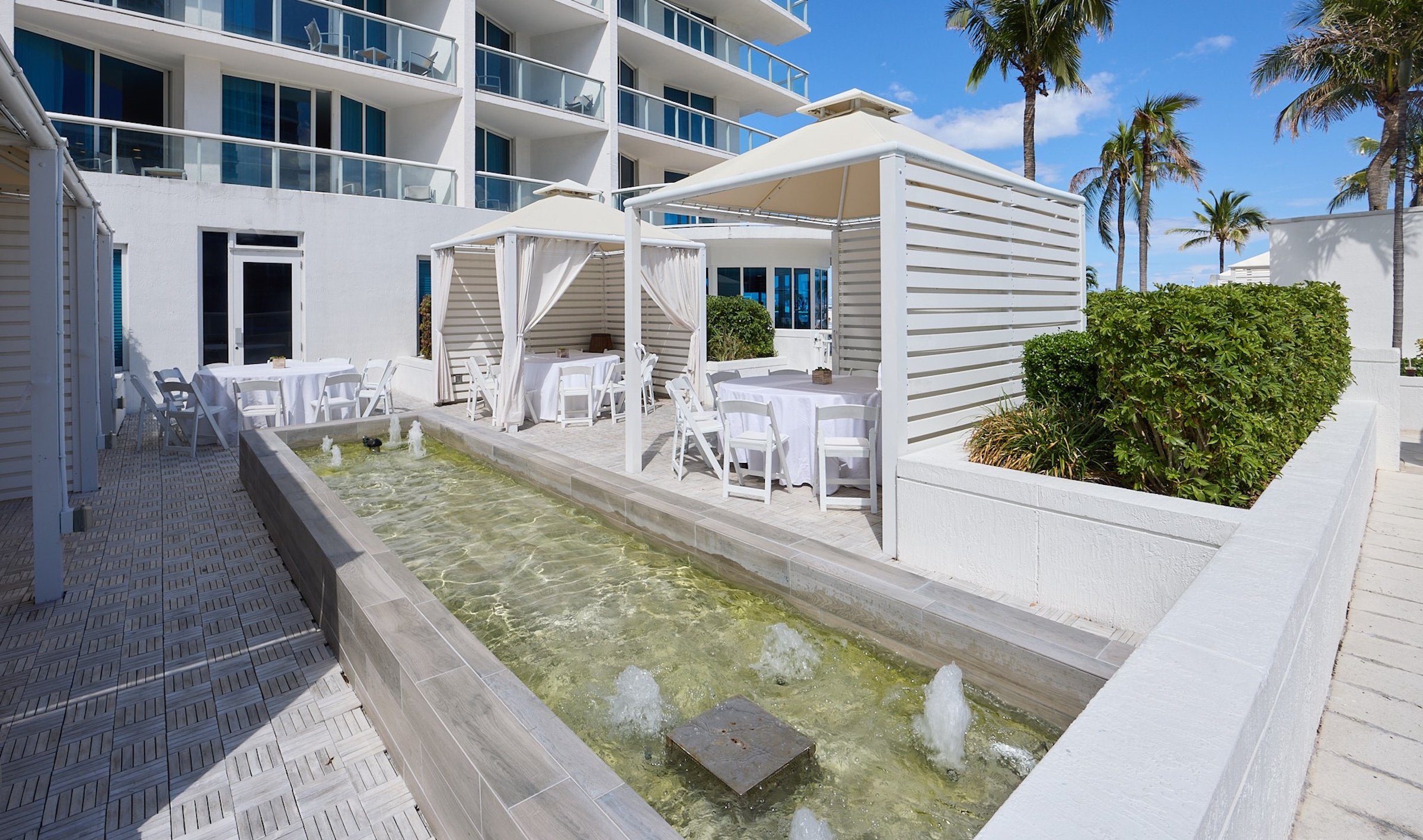 A row of poolside cabanas next to a fountain