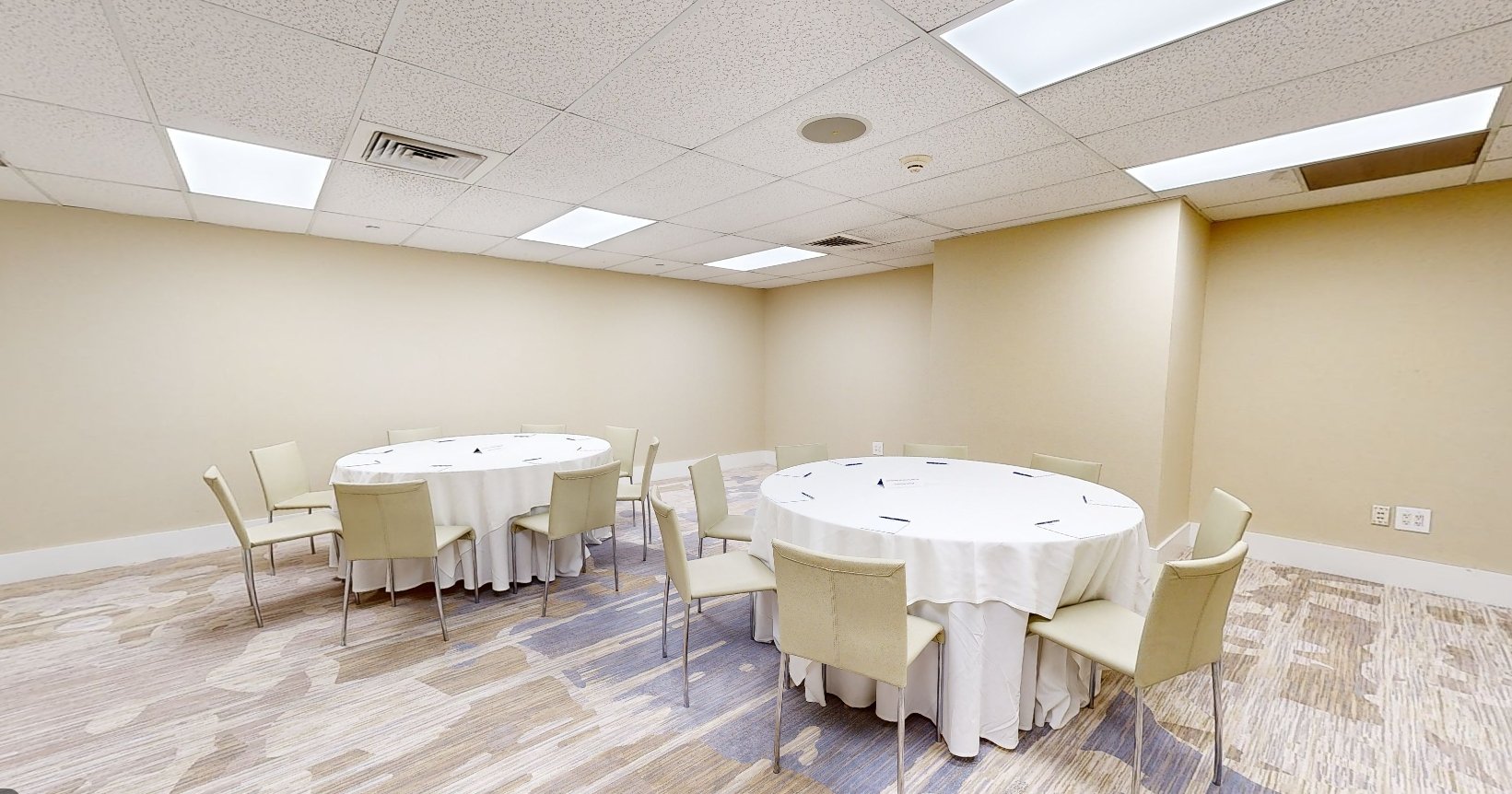 The Sun room at Beach House Fort Lauderdale, with two round tables surrounded by chairs