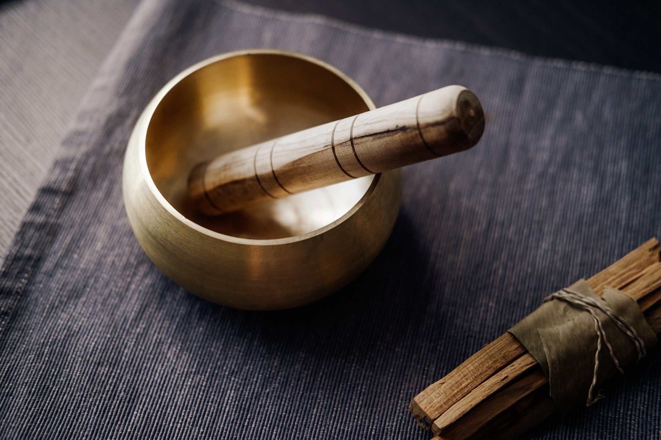 A bronze sound healing bowl on a grey mat