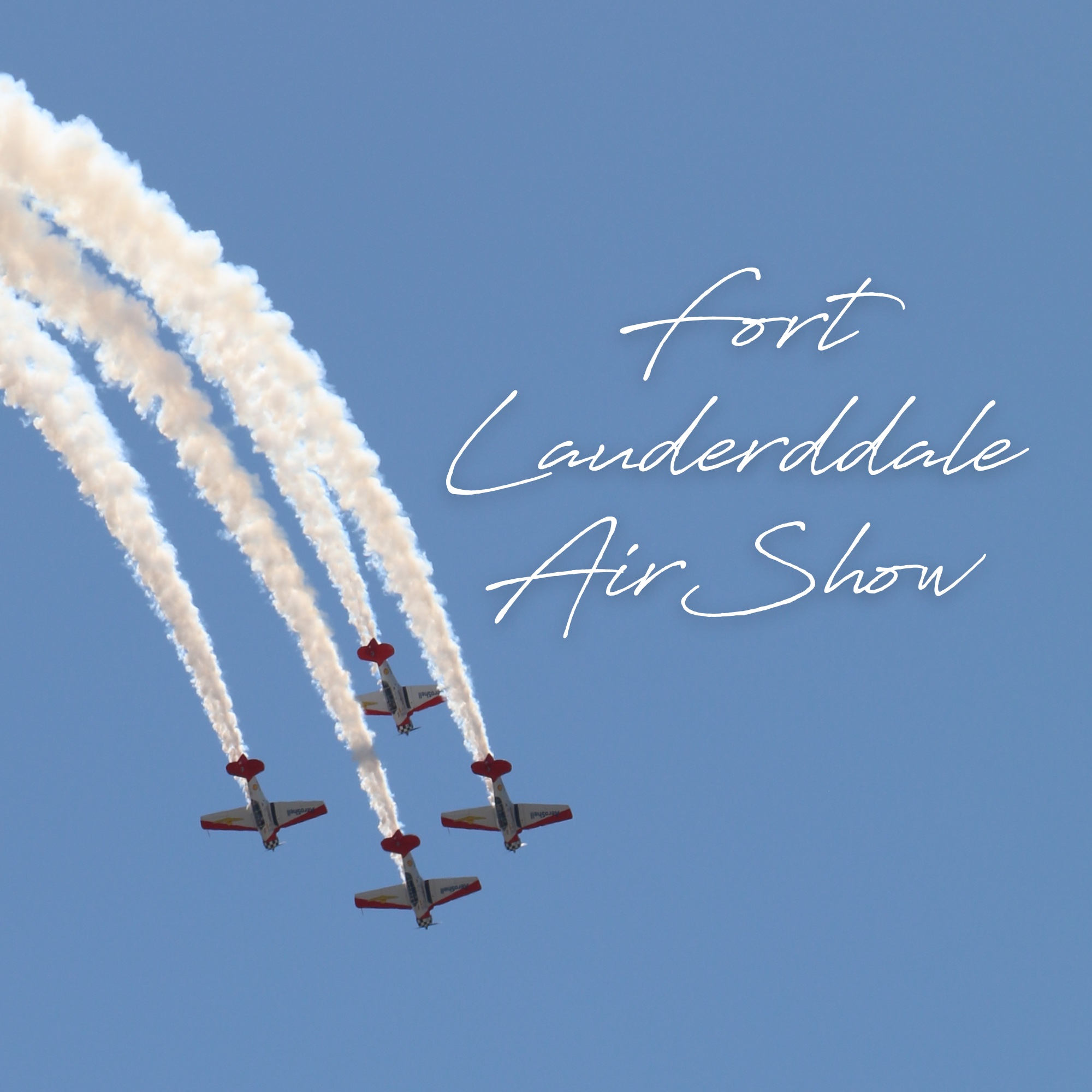 Four jets flying in formation leaving trails behind them, with the words