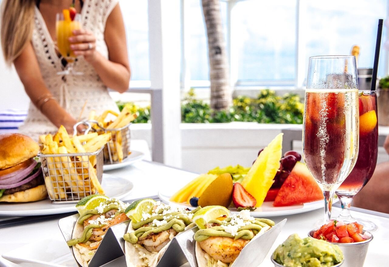 a close up view of a tacos and burgers on a white table