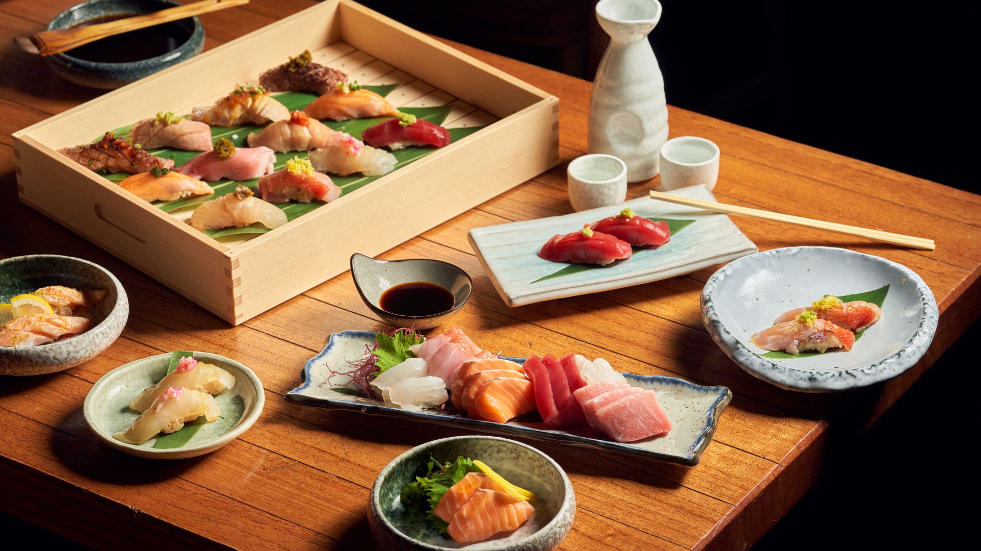 Assorted sushi on a wooden table and Japanese style serving dishes