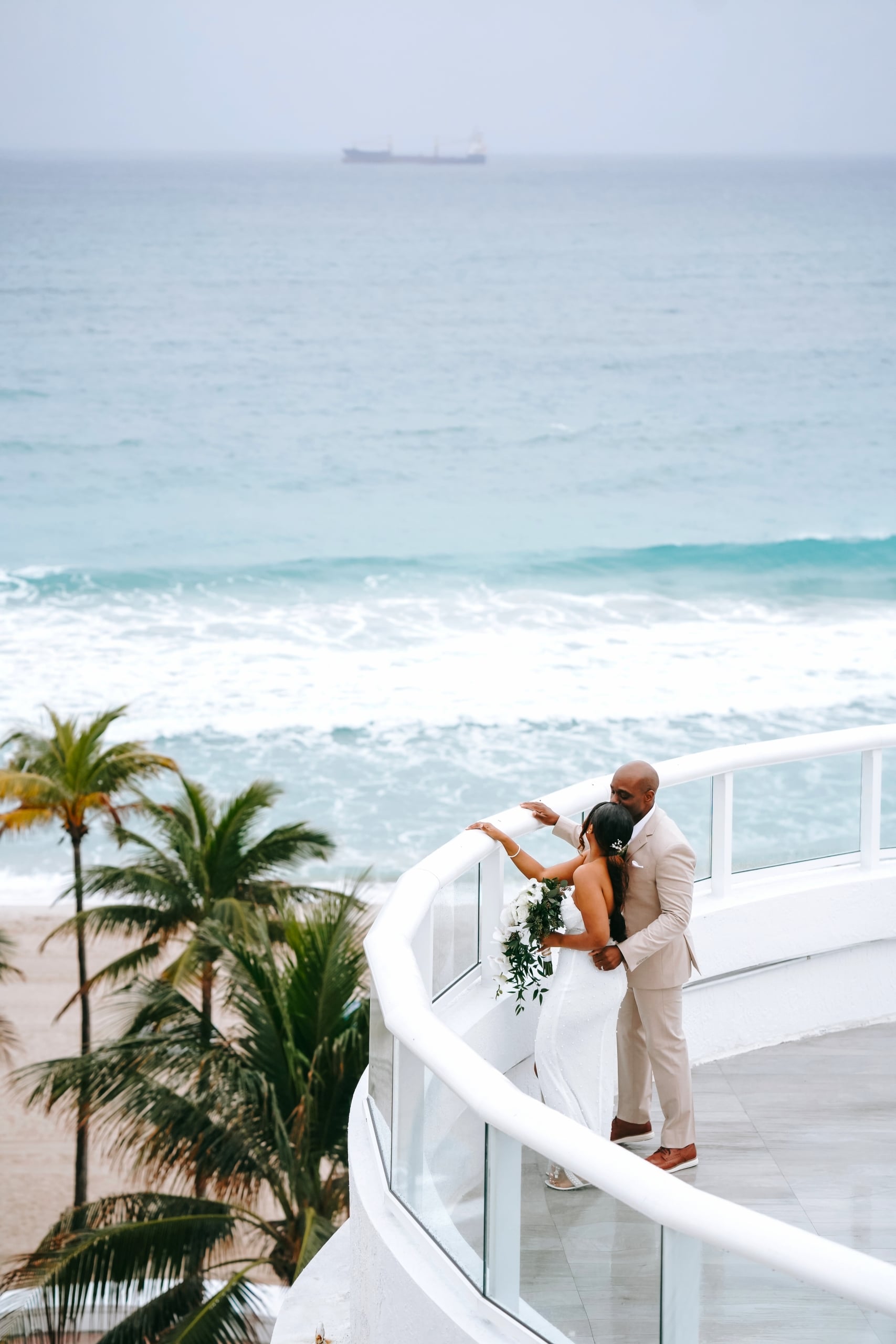 Couple on the Rotunda facing the ocean with palm trees swaying